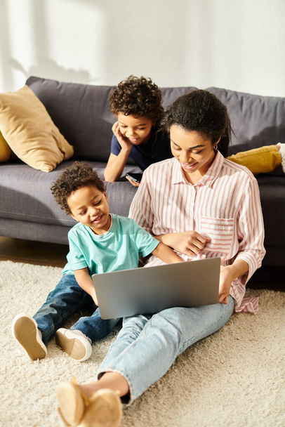 cheerful african american woman in cozy attire watching movies with her adorable sons at home - Photo, Image