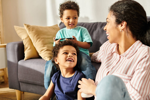 bella allegra donna africana americana guardando i suoi figli adorabili gioiosi mentre a casa - Foto, immagini