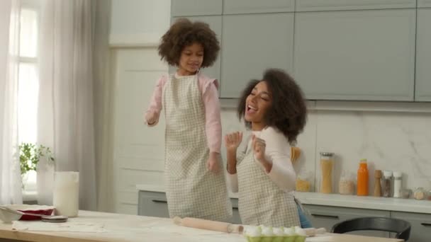 Šťastná rodina Afričanky americká matka s malou dceruškou spolu vaření pečení těsto mouka kuchař baví kulinářské maminka s dítětem dítě holčička tanec vychutnat hudbu domácí strana kuchyně blázinec tanec - Záběry, video