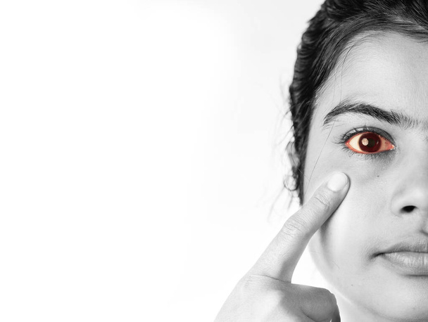 Vista cercana monocromática del ojo amarillo rojizo de una mujer india, concepto de cuidado de la salud - Foto, Imagen