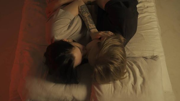 Love intimate relationships. Top view young loving couple romantic time in bedroom. Man and woman half naked sensual lovers laying in bed together, passion, intimacy kissing, foreplay and bonding. - Photo, Image