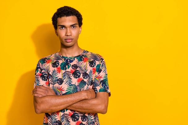 Photo of funky confident man wear print t-shirt arms crossed empty space isolated yellow color background. - Zdjęcie, obraz