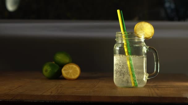 Limón y lima sabor agua gaseosa servida en vidrio beber medio 4k tiro cámara lenta enfoque selectivo - Imágenes, Vídeo