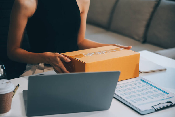 businesswoman start small business and successful SME entrepreneurs asian woman hoding boxs works from home delivering parcels online. SME delivery concept and packaging - 写真・画像