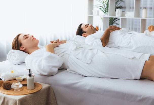 Kaukaska para klientów korzystających relaksujący masaż antystresowy spa i rozpieszczający z rekreacji skóry piękna rekreacji w dzień światło ambient salon spa w luksusowym ośrodku lub hotelu. Cichy zapach - Zdjęcie, obraz