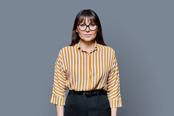 Portrait of serious middle aged business woman on white background. Confident female with glasses looking at camera. 40s professional, beauty health lifestyle work business services - Fotoğraf, Görsel