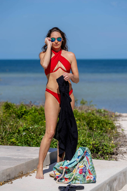 Νεανική ομορφιά απολαμβάνει στον ήλιο της Καραϊβικής δίπλα στην πισίνα, απολαμβάνοντας μια όαση διακοπών ζεστασιάς, χαλάρωσης και καθαρής ευδαιμονίας - Φωτογραφία, εικόνα