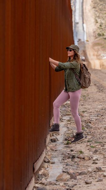 Migrante desesperado navega no muro da fronteira de Jacumba, buscando a entrada ilegal nos Estados Unidos, destacando os desafios de imigração em curso - Foto, Imagem