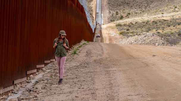 Desperate migrant navigates the Jacumba border wall, seeking illegal entry into the United States, highlighting ongoing immigration challenges - Photo, Image