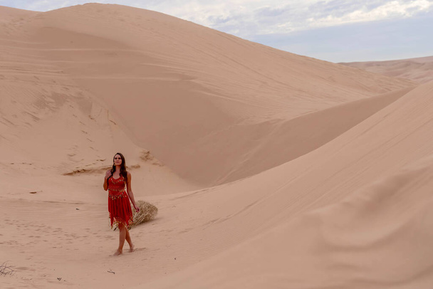 Витончена модель охоплює красу природи в піщаних дюнах, уособлюючи елегантність на тлі величезної, природної пишноти - Фото, зображення