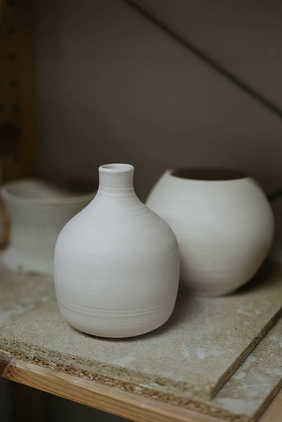 Ряд незакінчених білих керамічних ваз на полиці студії. - Фото, зображення