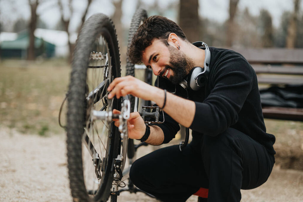 Un uomo d'affari gode di tempo libero fissare la sua moto in un ambiente parco, combinando business e fitness. - Foto, immagini