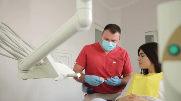 Un dentiste évalue l'état des dents d'une femme dans un cabinet dentaire, assurant ainsi sa santé dentaire.. - Séquence, vidéo