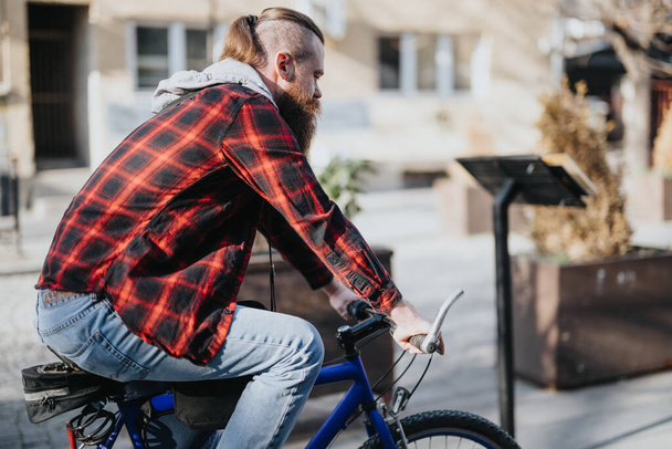都市部の青い自転車のヒップスターのビジネスマンは,都市のライフスタイルのバイブでリモートで彼のスマートフォンで作業するために停止. - 写真・画像