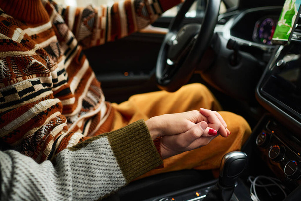Nerozpoznatelná mladá žena drží ruku svého přítele při cestování autem v zimní den - Fotografie, Obrázek
