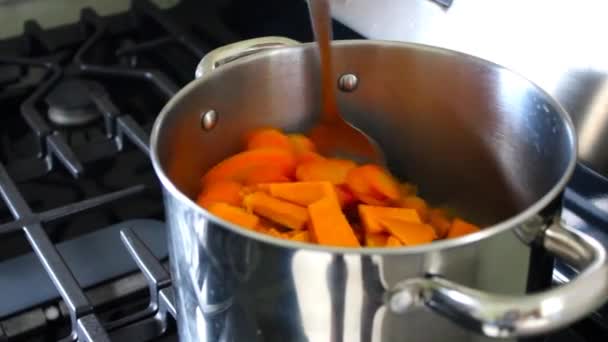 Agitar a mano las verduras con cuchara en la olla de cocción en la estufa - Metraje, vídeo