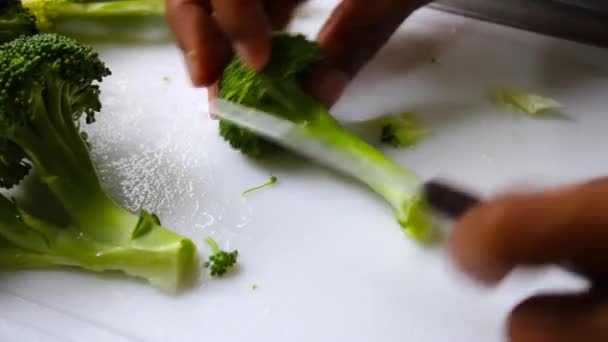 Manos cortando verduras frescas de brócoli verde con cuchillo - Metraje, vídeo