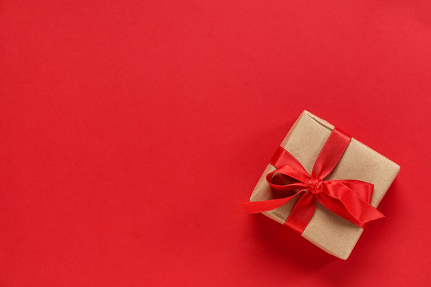 Geschenkkarton mit Band auf rotem Hintergrund. Valentinstag-Feier - Foto, Bild