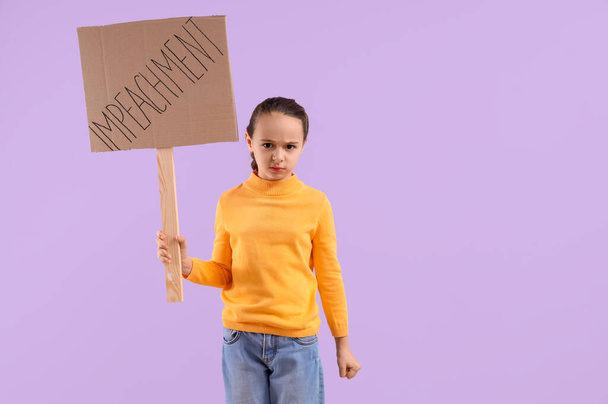 Protesting little girl holding placard with word IMPEACHMENT on lilac background - Photo, Image