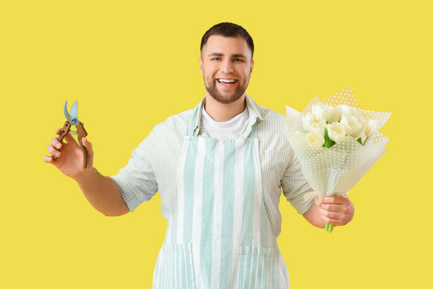mężczyzna kwiaciarnia z kwiaty na żółtym tle - Zdjęcie, obraz