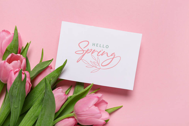 Pozdrowienia z tekstem HELLO SPRING i piękne tulipany na różowym tle - Zdjęcie, obraz