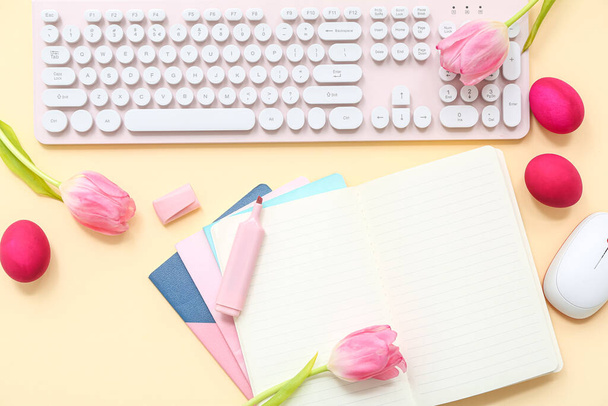 Pisanki, notatnik, tulipany, znacznik, klawiatura komputera i mysz na żółtym tle - Zdjęcie, obraz