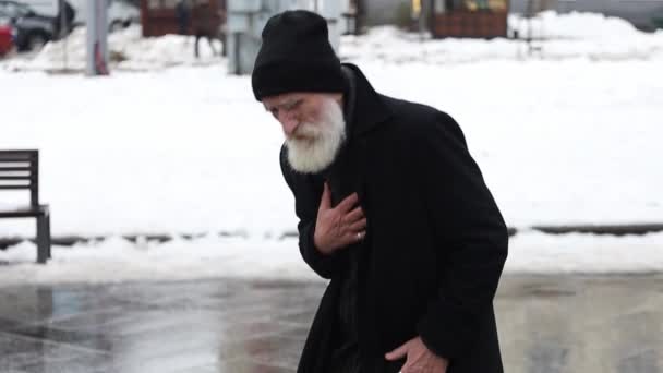 Старий дідусь мав серцевий напад, стоячи на вулиці у зимовому верхньому одязі. Здоровий старий на вулиці - Кадри, відео