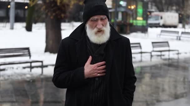 Yaşlı bir büyükbaba, kış kıyafetiyle dışarıda dururken kalp krizi geçirdi. Sokaktaki sağlıksız yaşlı adam - Video, Çekim