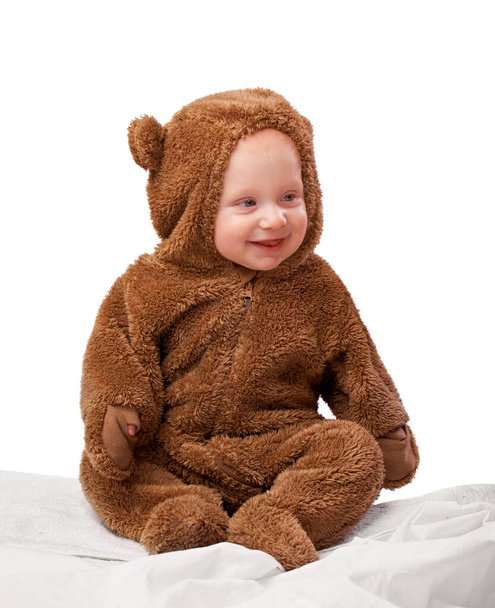 Στούντιο, μωρό και φορεσιά με κοστούμι, αρκούδα και νήπιο με χαρά και διασκέδαση. Παιδί, νεογέννητο και την ευτυχία με αξιολάτρευτο, άνεση και ντύθηκε το βρέφος για την ανάπτυξη απομονώνονται σε λευκό φόντο. - Φωτογραφία, εικόνα