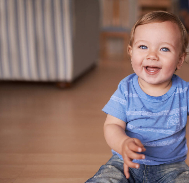 Boy, baby and smile for curiosity in home, joy and kid to relax in living room on floor. Child development, happy toddler and calm or comfortable, wellness and weekend for health and positive growth. - Photo, Image