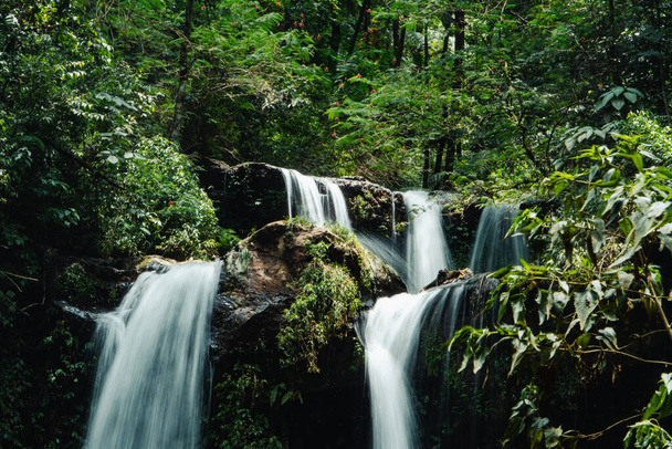 Ein saisonaler Wasserfall, der inmitten der Wildnis immer noch natürlich ist, wird Grenjengan Kembar Wasserfall genannt. Detailfotos des Wasserfalls mit langsamer Verschlusszeit - Foto, Bild