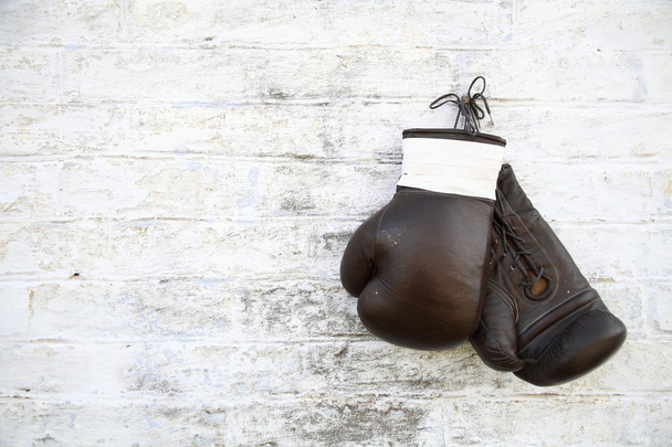 Παλιά γάντια του μποξ κρεμά σε έναν τοίχο από τούβλα - Φωτογραφία, εικόνα