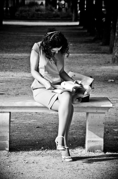 PARIS - France - 17 June 2012  - Woman with white dress reading at tuileries garden - Photo, Image