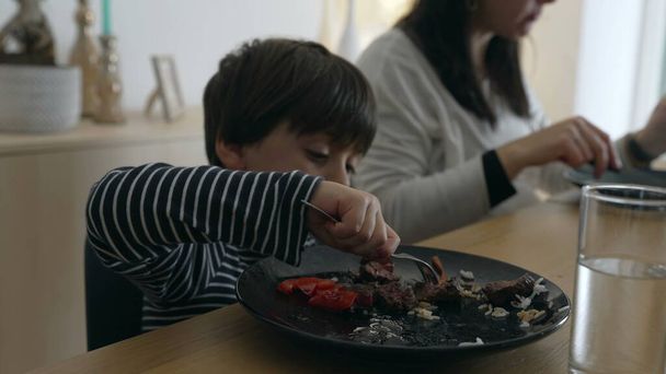 Petit garçon mangeant un repas équilibré à la maison pour le déjeuner en famille. enfant de 5 ans utilisant fourchette par lui-même profiter de la nourriture - Photo, image