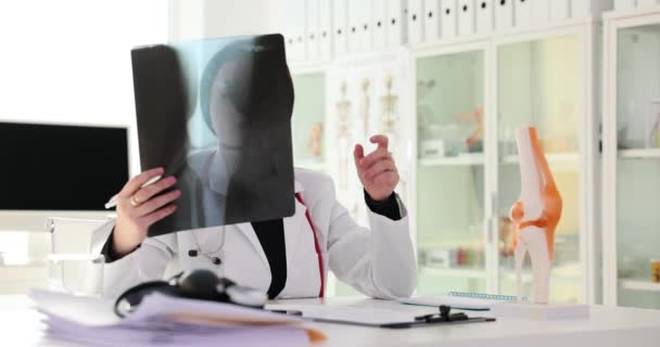 Csontbetegség és ortopéd traumatológus elemez egy térdsérülést a férfi lábon. Röntgenképek a beteg térdéről a klinikán - Felvétel, videó