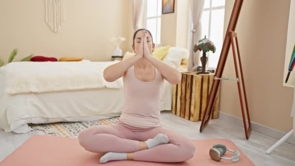 Mujer practicando yoga en un hogar tranquilo interior, mostrando bienestar y serenidad durante la meditación. - Metraje, vídeo