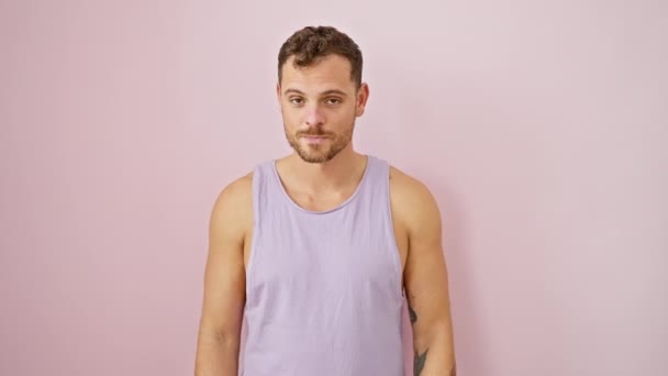 Verblüffter junger Mann in ärmellosem T-Shirt über rosa! Überraschung erfülltes Gesicht, offenes Maul in staunendem Unglauben, natürlich amüsanter und aufgeregter Ausdruck. - Filmmaterial, Video