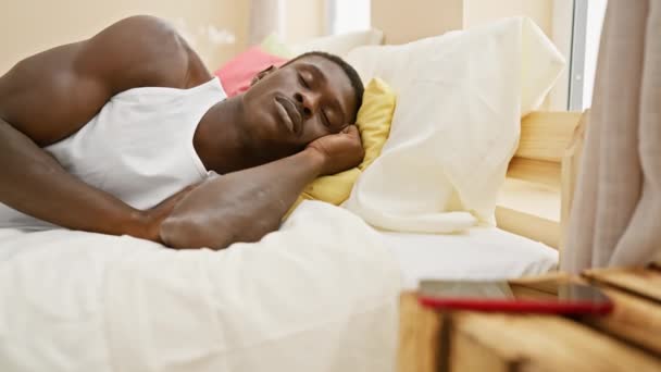 Afrikalı bir adam evdeki parlak, rahat bir yatak odasında rahat bir şekilde uyuyor, gündüzleri dinleniyor.. - Video, Çekim