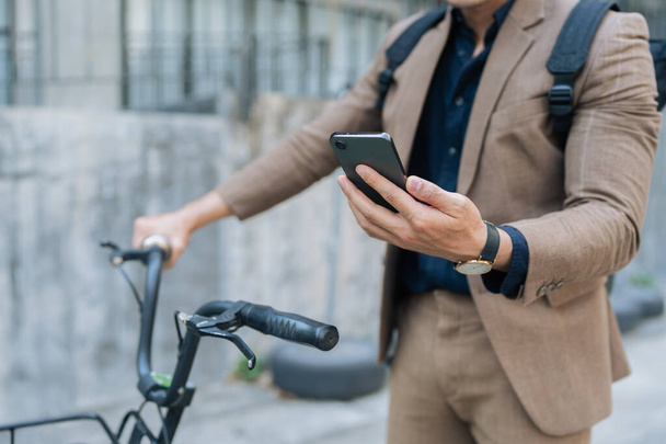 aziatische jonge zakenman gebruik maken van smart phone tijdens het woon-werkverkeer in de stad. Milieuvriendelijk. - Foto, afbeelding