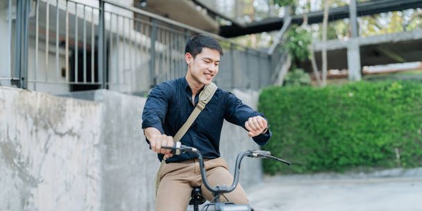エコフレンドリーな代替車グリーンエネルギーを動作する都市バイクにスーツの若いビジネスマン. - 写真・画像