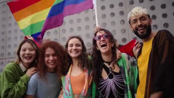 Una multitud de personas felices en colorida sonrisa para una selfie con una bandera de arco iris, capturando su diversión y ocio de viaje. Amigos gays y lesbianas juntos en el desfile del orgullo gay. Concepto LGBT - Imágenes, Vídeo