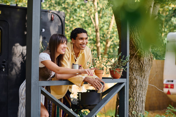 Bir erkek ve bir kadın verandadaki bir ağacın yanında oturmuş, sakin doğal çevrenin tadını çıkarıyorlar.. - Fotoğraf, Görsel