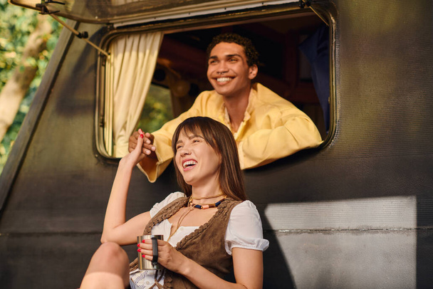 Un hombre y una mujer están tranquilamente sentados juntos en una furgoneta, mirando por la ventana mientras viajan. - Foto, Imagen