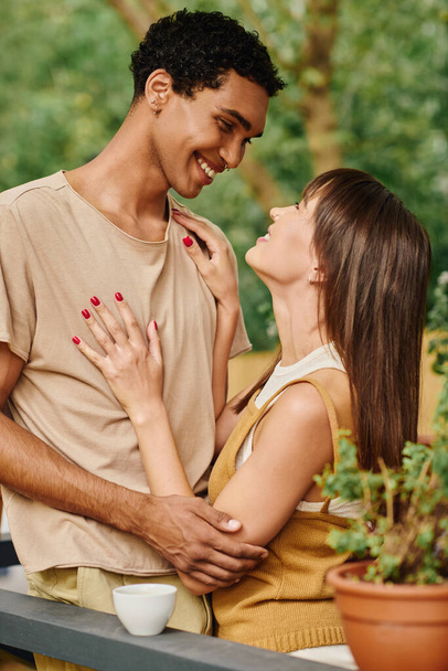 Ένα διαφυλετικό ζευγάρι στέκεται μαζί, αγκαλιασμένοι μπροστά από ένα τροχόσπιτο, ενσαρκώνοντας την αγάπη και την ενότητα κατά τη διάρκεια της ρομαντικής τους απόδρασης. - Φωτογραφία, εικόνα