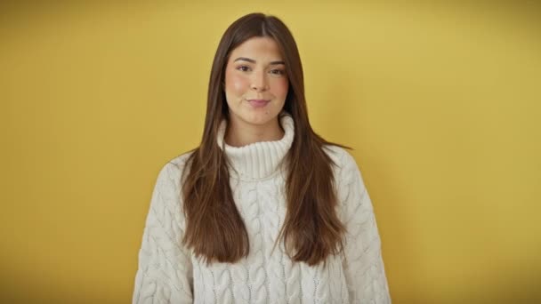 Élénk magabiztos, mosolygós fiatal spanyol nő áll szemben a sárga fal elszigetelt háttér, barátságos, sikeres üzleti kézfogás. gyönyörű pulóvert visel, bizalmat mutat. - Felvétel, videó