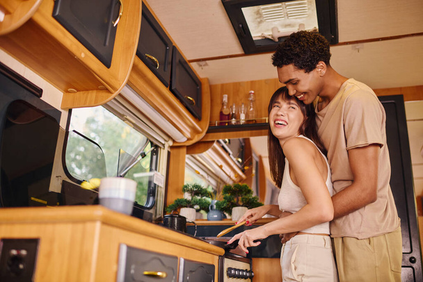 Mies ja nainen seisovat yhdessä kodikas keittiö, jakaa hetken yhdessä, kun he valmistavat aterian. - Valokuva, kuva