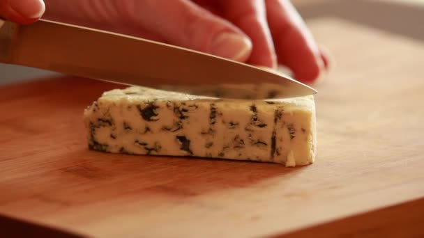  vrouw handen hakken, snijden blauwe kaas op houten plank close-up - Video