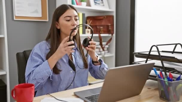İspanyol kadın yönetici modern ofiste kulaklığı inceliyor. - Video, Çekim