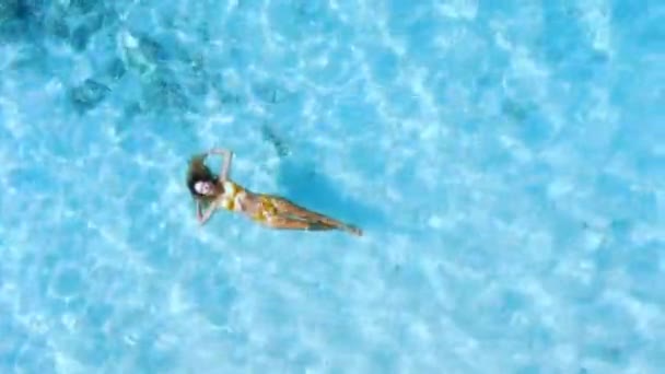 Luftaufnahme von oben nach unten der schönen Frau schwimmt in transparenten blauen Ozean. Hochwertiges 4k Filmmaterial - Filmmaterial, Video