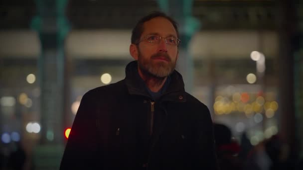 Giovane uomo con gli occhiali che guarda spettacolo di luce in città di notte - Filmati, video